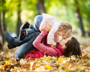 mother with child in autumn leaves