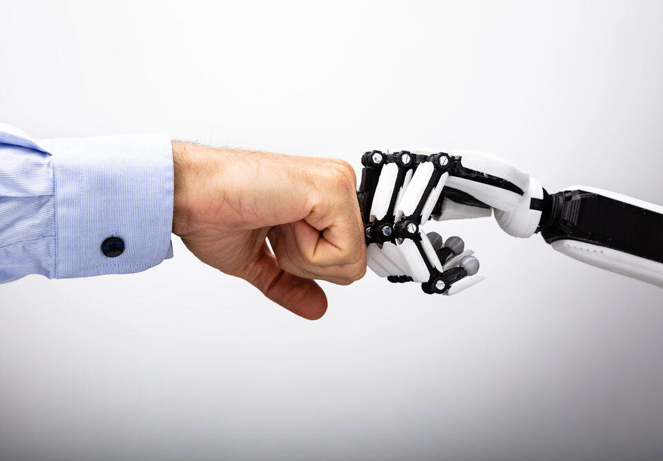 AI robot hand fistbumping a human hand